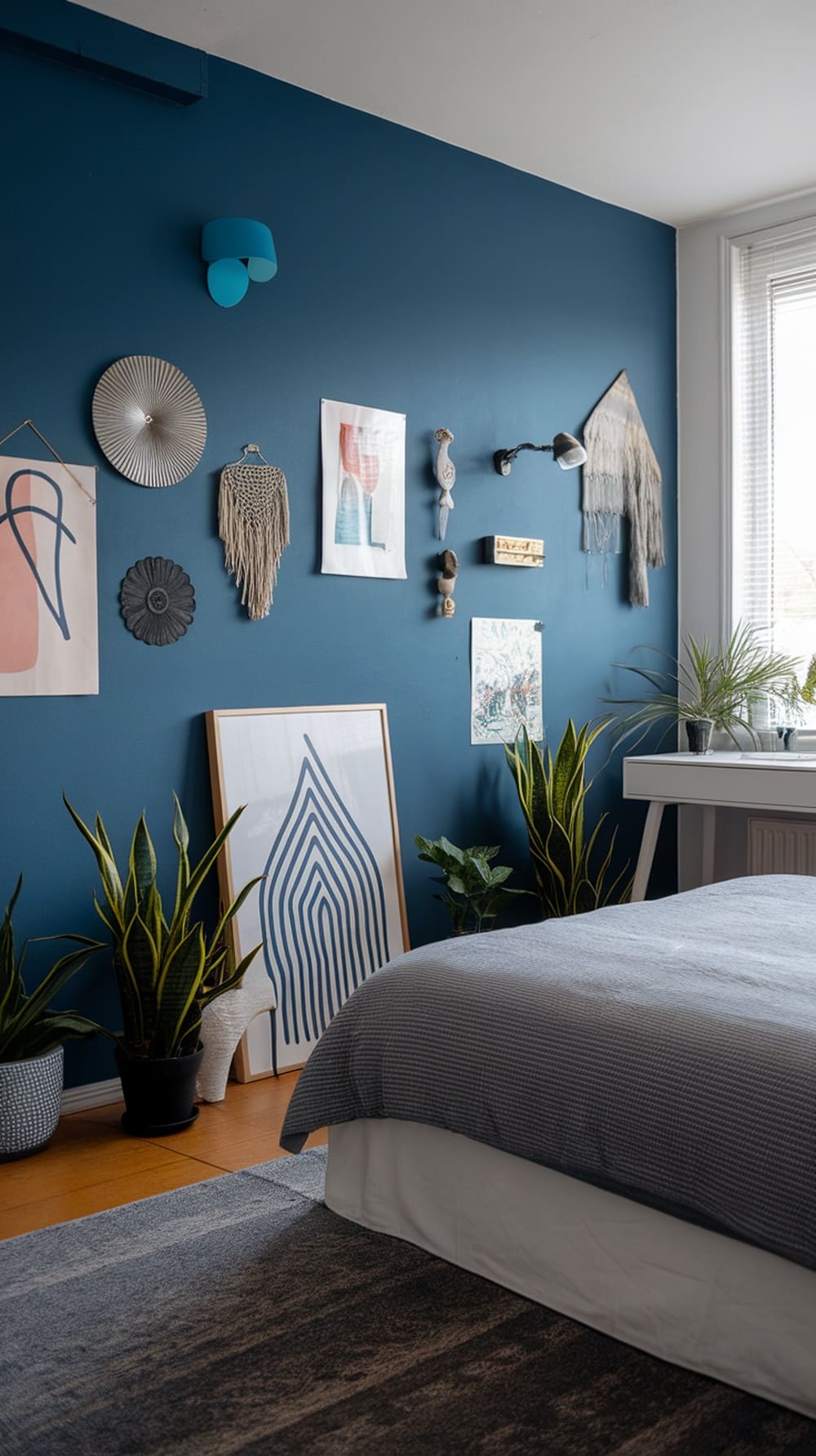 A stylish bedroom featuring an indigo accent wall adorned with various artworks and plants.