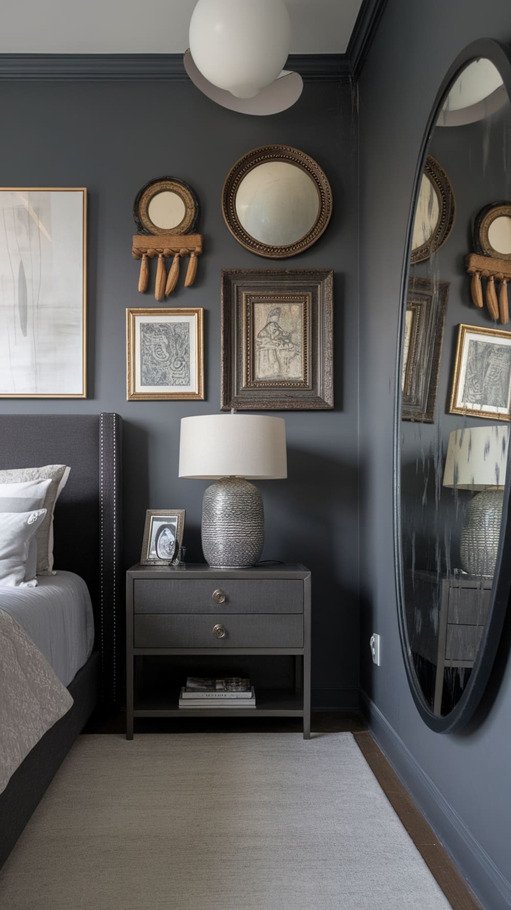 Artistic wall decor in a charcoal gray bedroom featuring various framed artworks and mirrors.