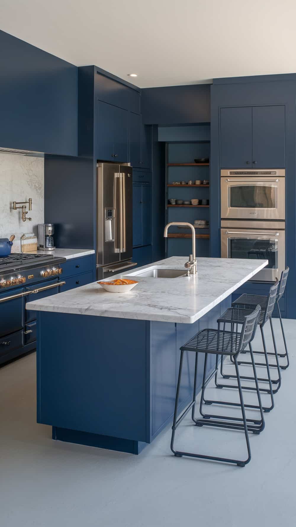 A modern kitchen featuring navy blue cabinets with integrated stainless steel appliances.
