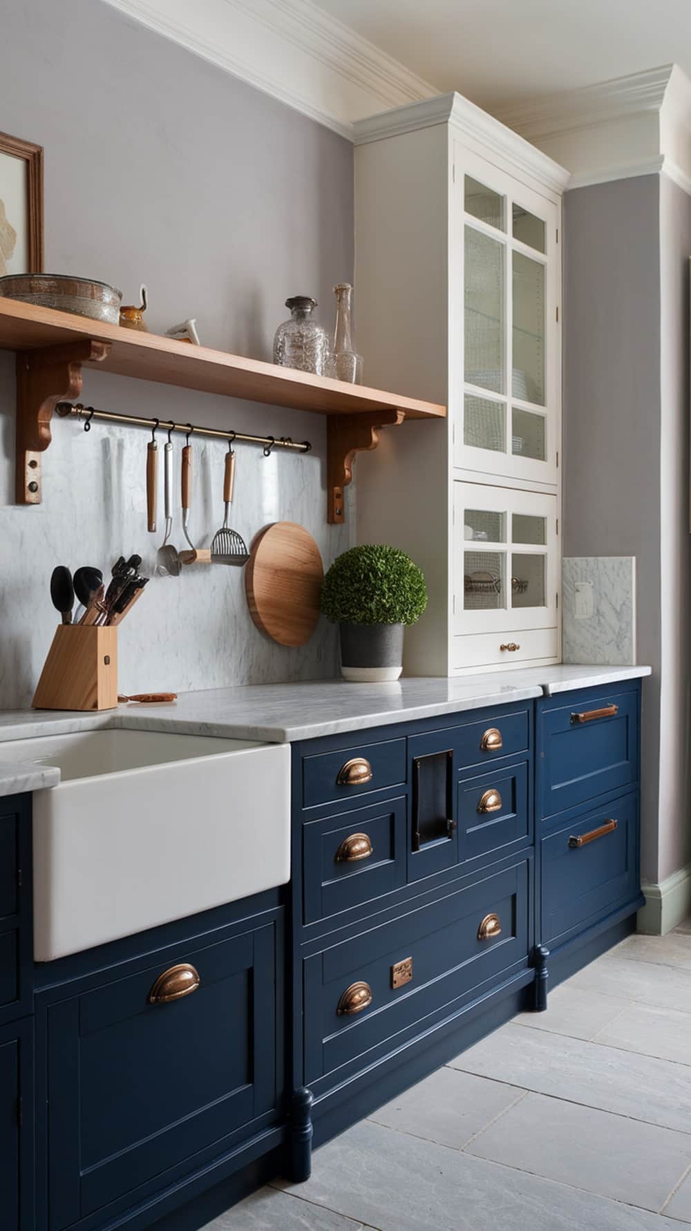 A modern kitchen featuring navy blue lower cabinets and white upper cabinets with brass hardware.