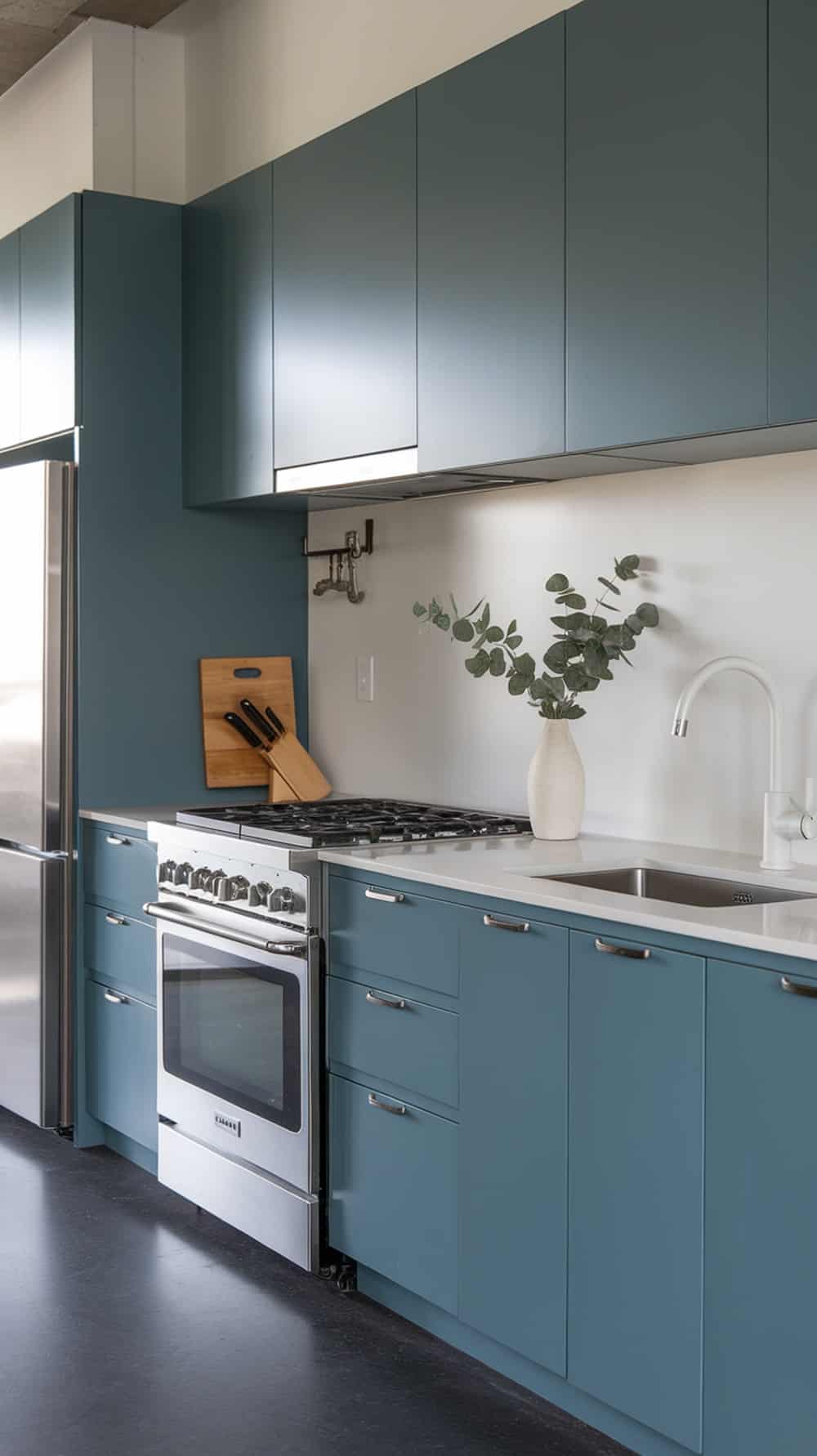 A modern kitchen featuring dusty blue cabinets with sleek design.