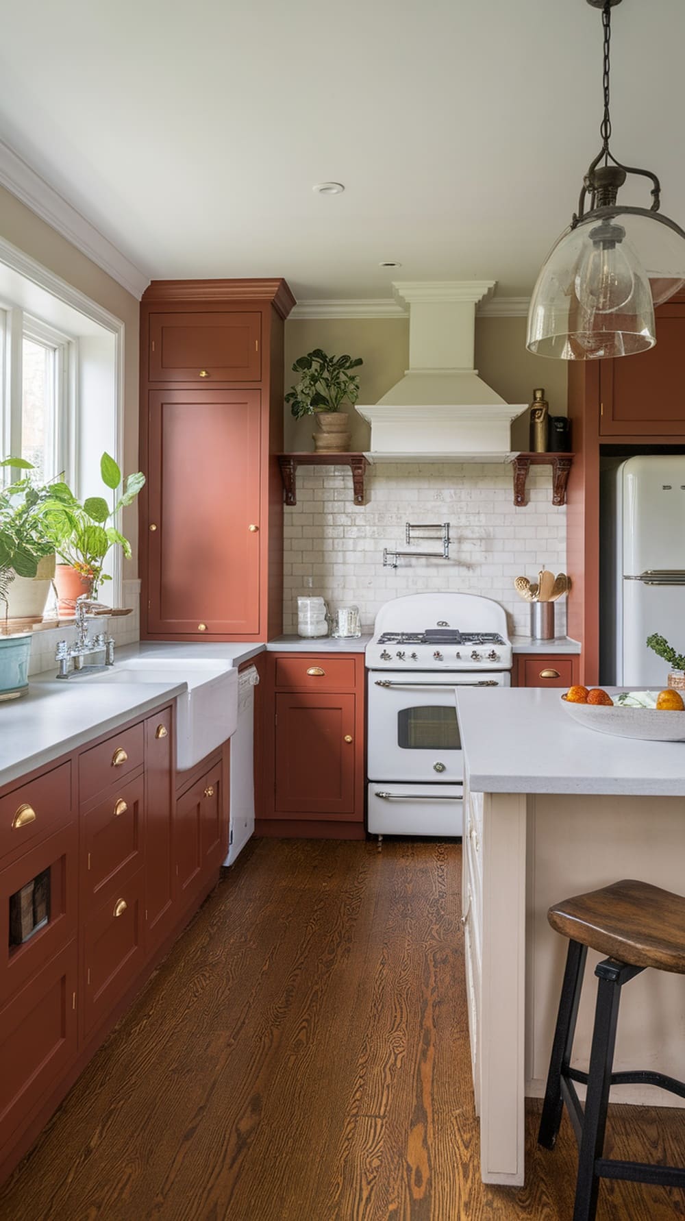 Transitional kitchen featuring rust orange cabinets, white countertops, and wooden flooring.