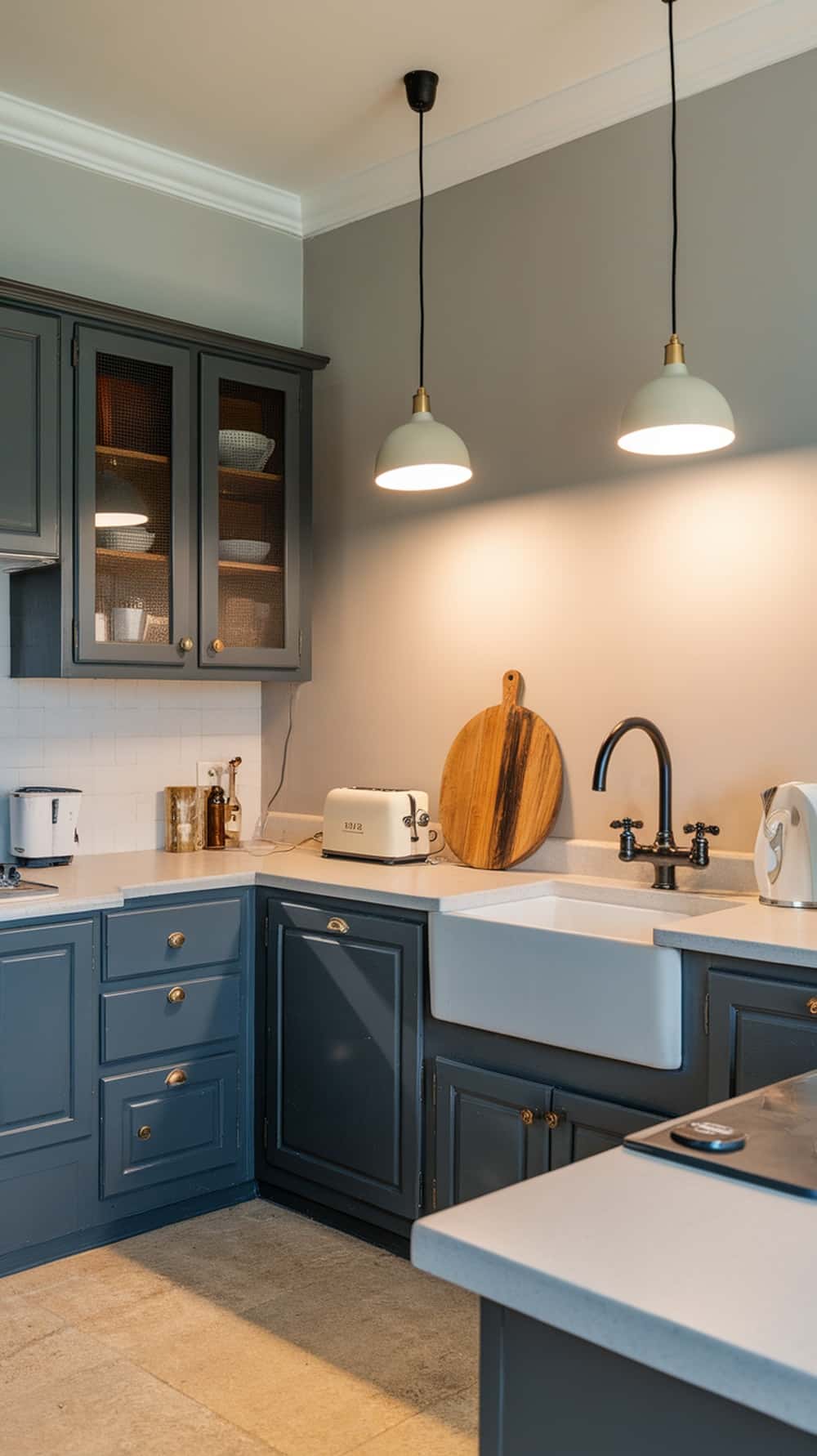 A stylish kitchen featuring charcoal gray cabinets with pendant lighting.