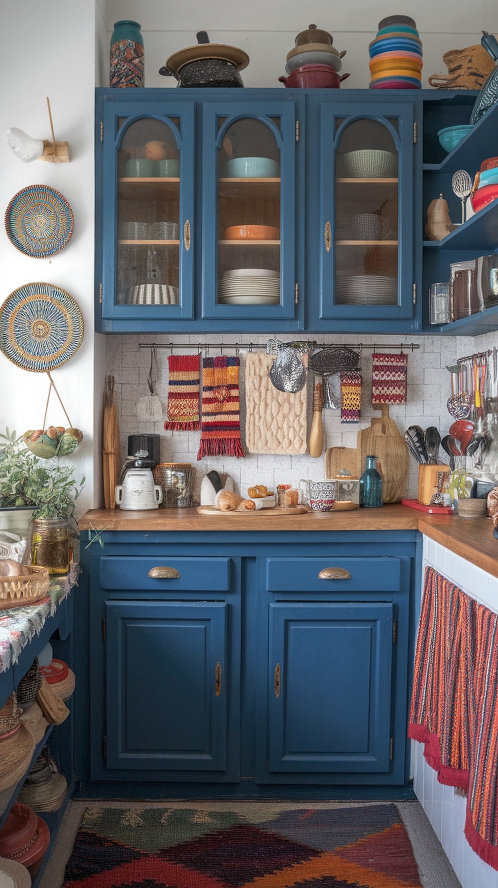 A cozy kitchen featuring moody indigo cabinets, colorful textiles, and eclectic decor.