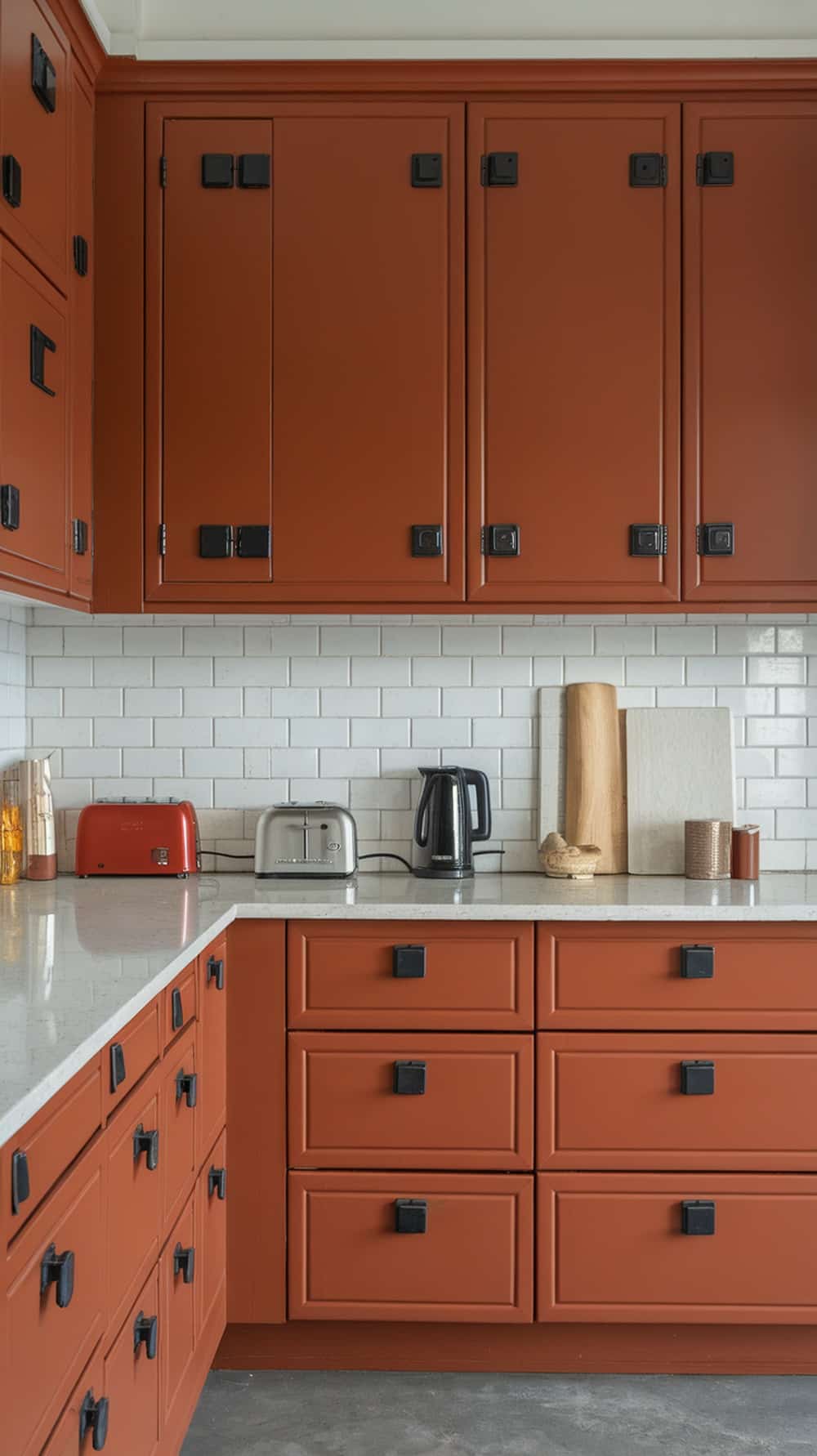 A kitchen featuring rust orange cabinets with black hardware, showcasing a modern and inviting design.
