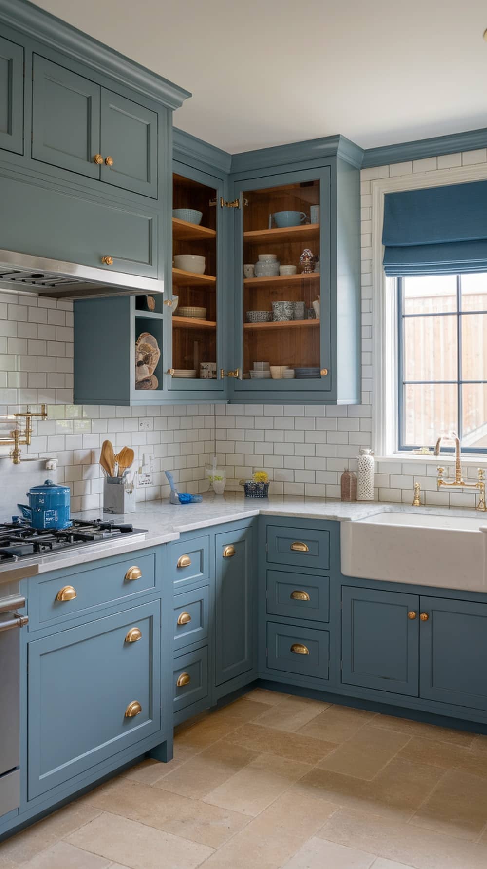 A modern kitchen featuring dusty blue matte finish cabinets with gold hardware and wooden shelves.