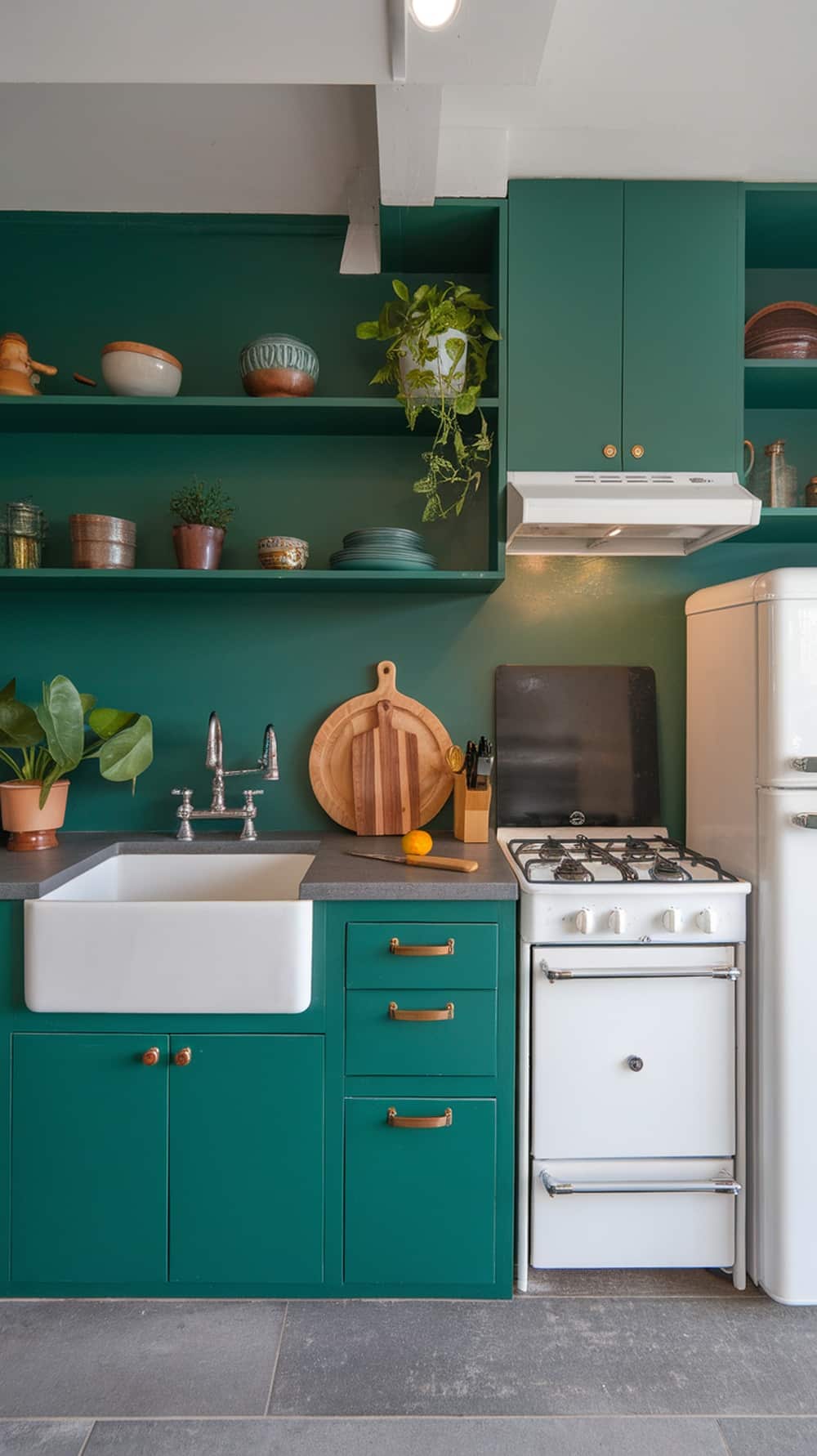 Stylish emerald green kitchen with open shelving and decorative items.