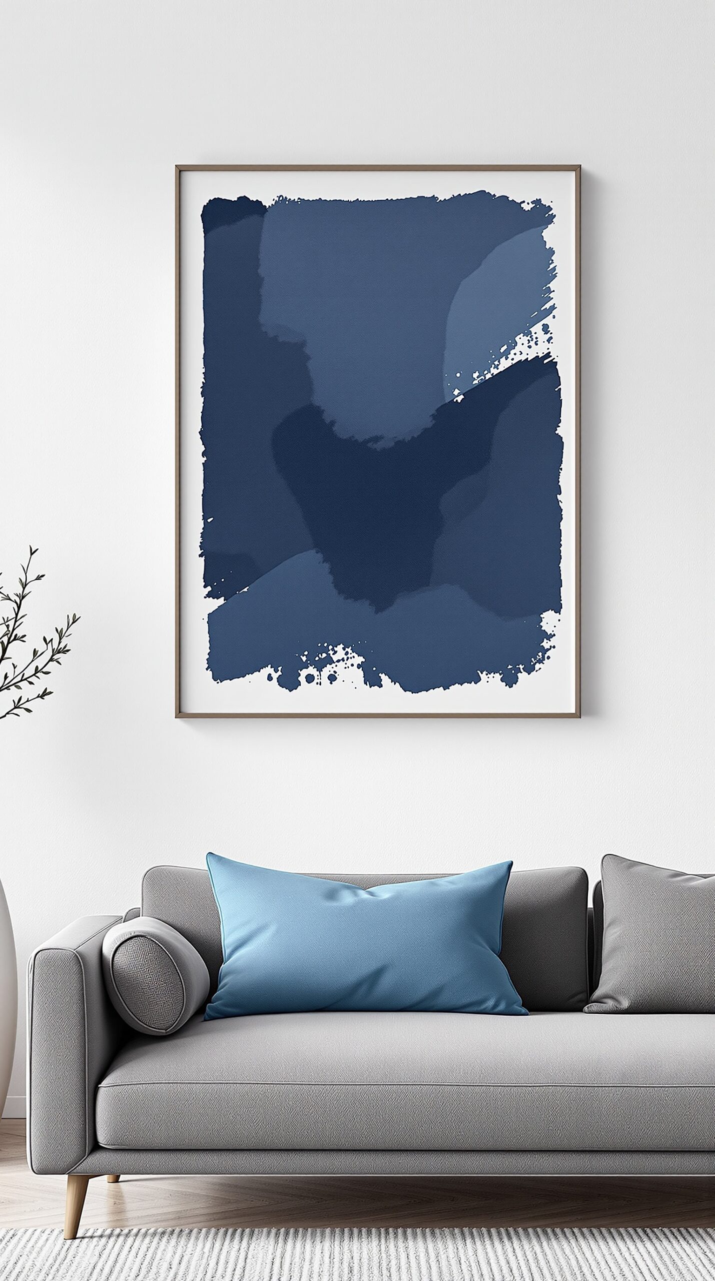 Minimalist navy blue artwork above a gray sofa with blue pillows