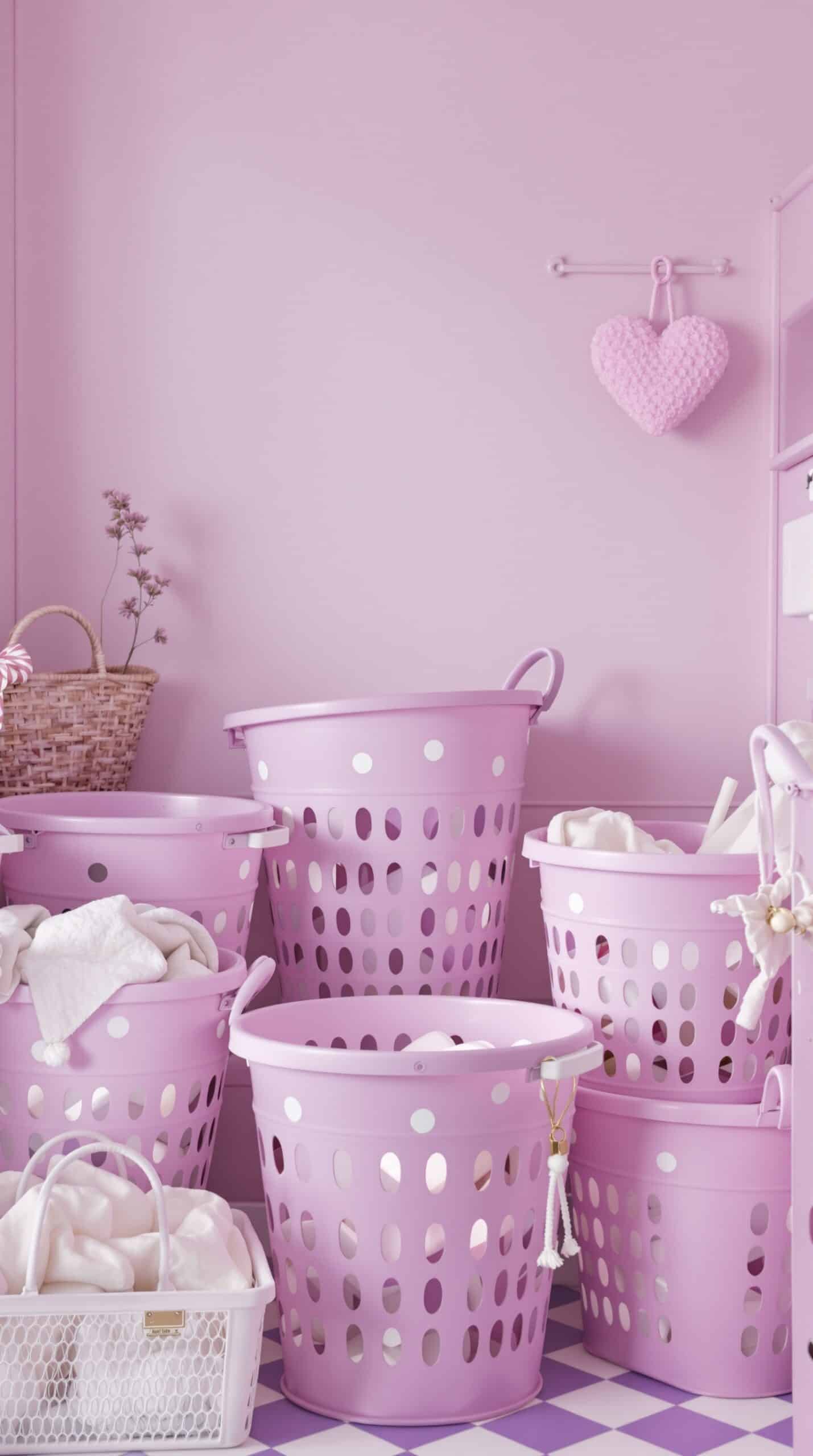 A collection of lavender laundry baskets in a pastel pink laundry room