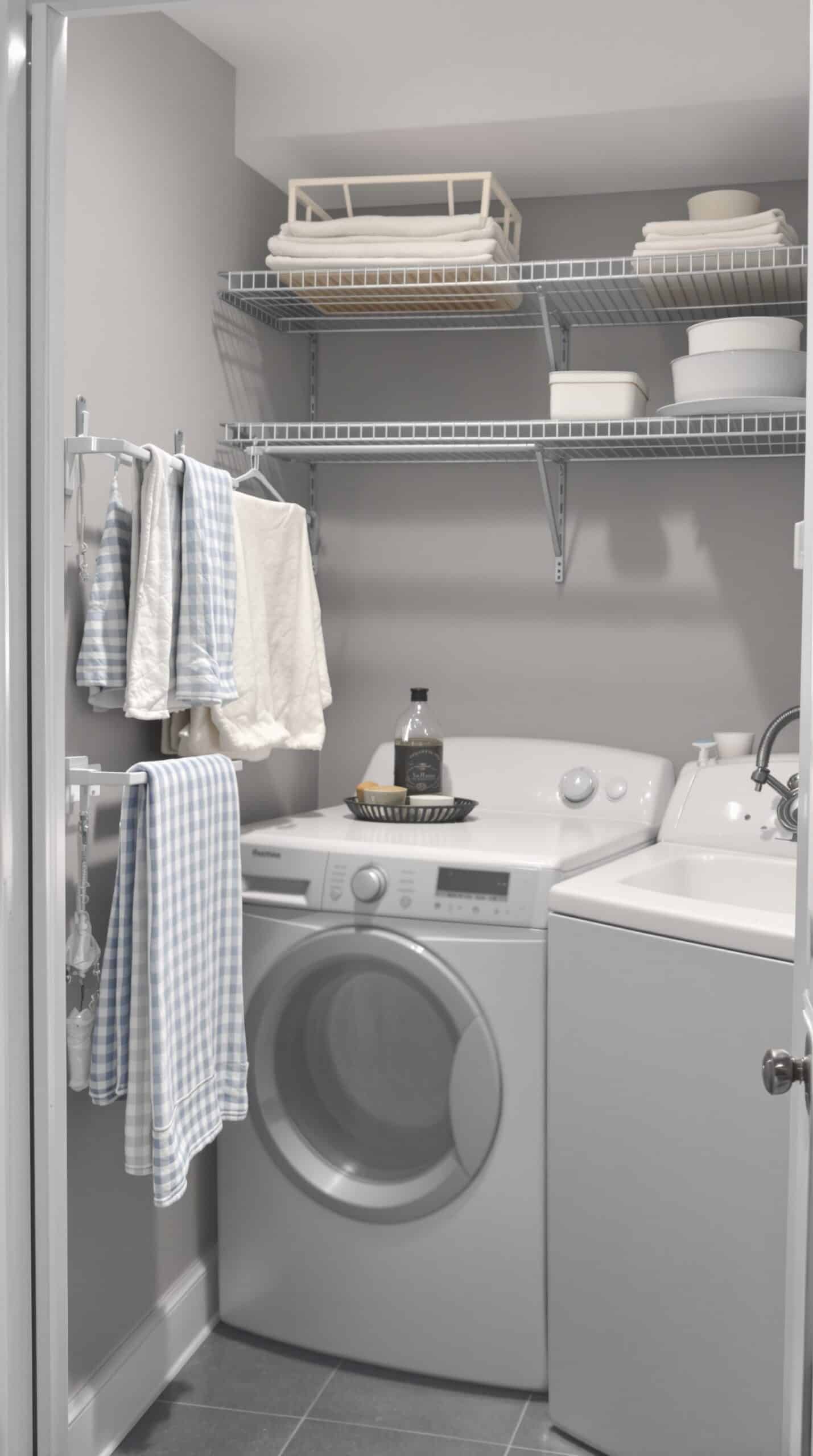 A small gray laundry room with shelves and hanging rods for efficient storage.