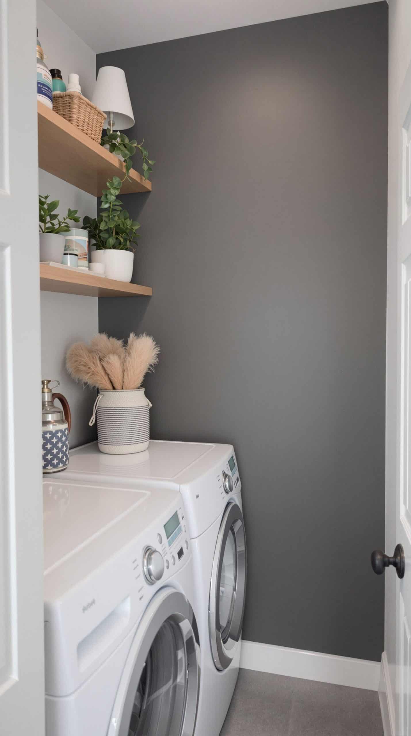 Laundry room featuring gray accent walls with white appliances and decorative shelves