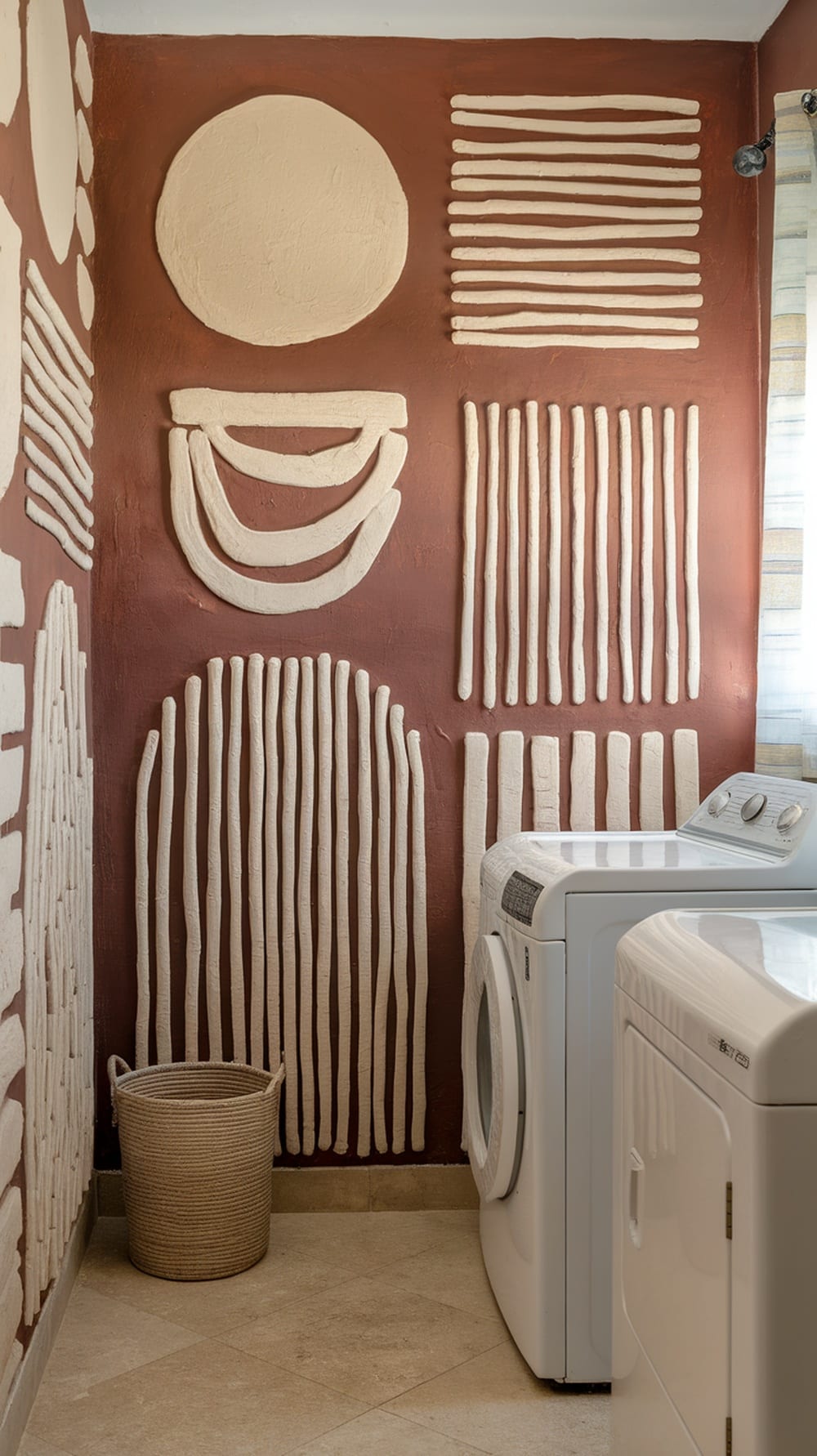 Textured terracotta wall art in a laundry room with white washing machines and a woven basket.
