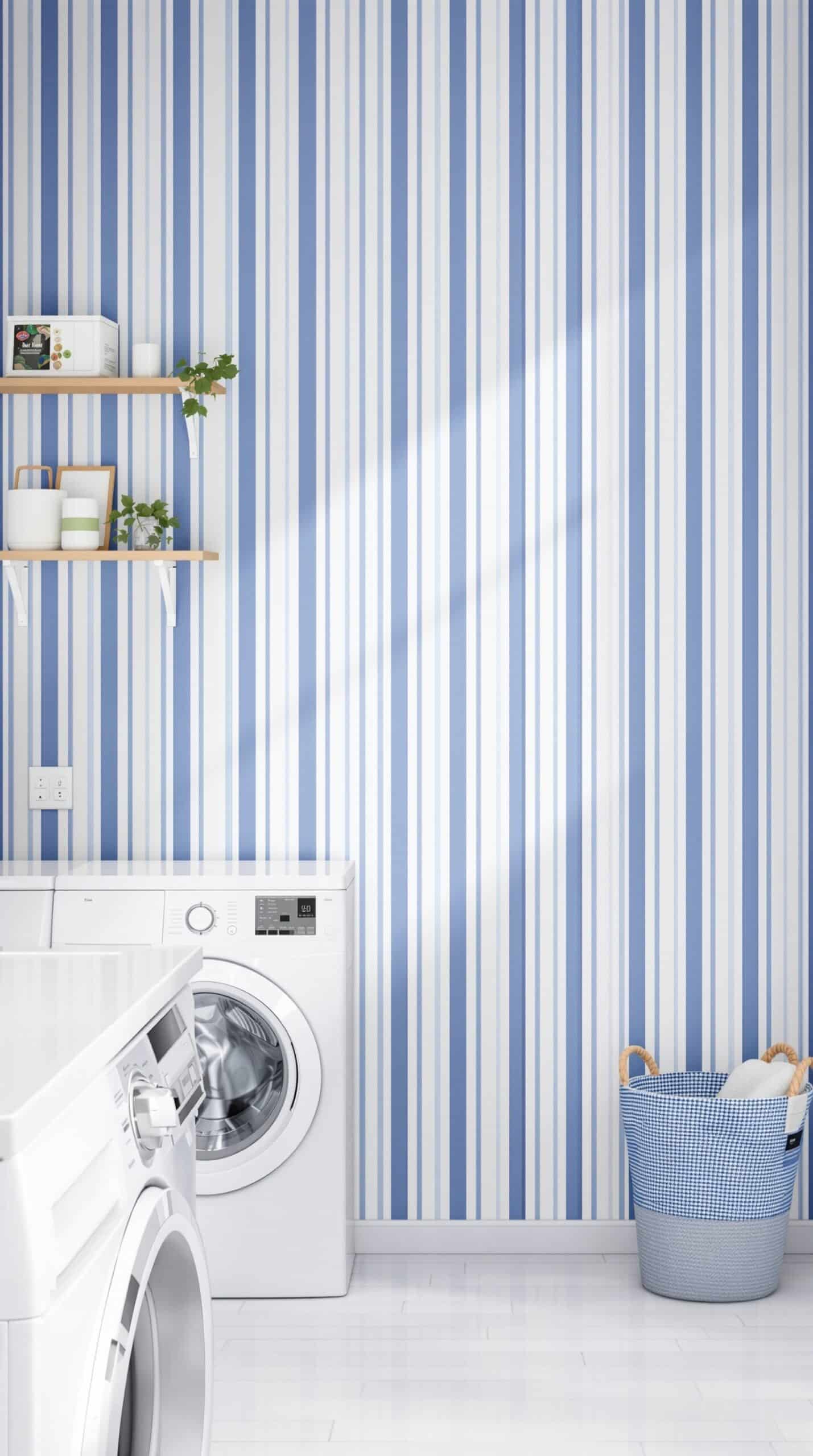 Laundry room with indigo and white striped wallpaper, white washing machine, and a blue basket.
